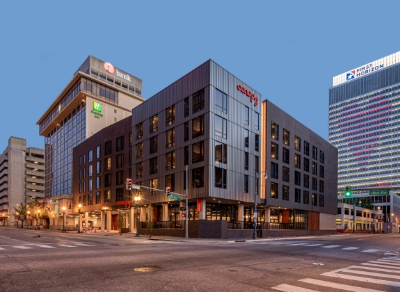 Four story hotel property at the corner of Union Ave and B.B. King Blvd at dusk with streetlights illuminating the roadway