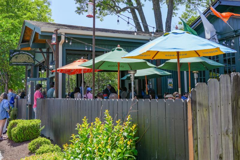 patio and umbrellas with people dining at Celtic crossing Irish pub