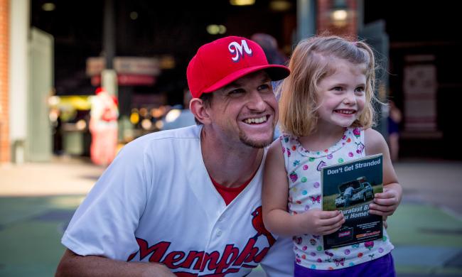 A Memphis Redbirds player posing with a little girl at AutoZone Park.