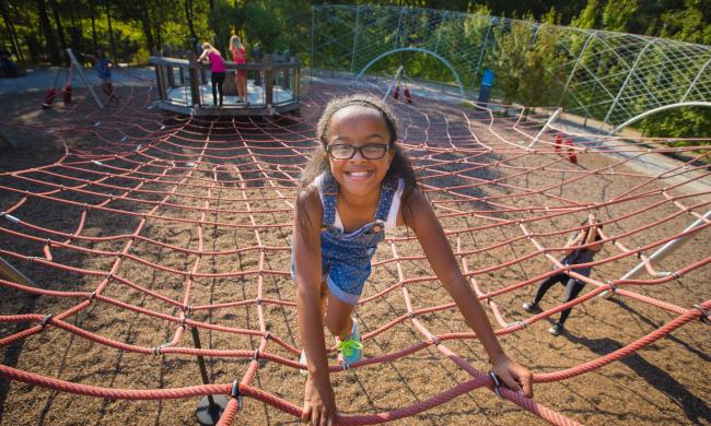 A girl climbing a feature at the Shelby Farms Park Playground