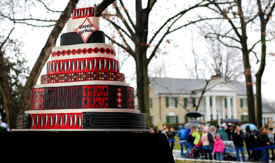 decorated multi-tier cake for elvis birthday in front of graceland mansion
